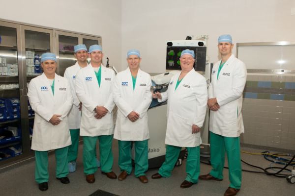 Group Of Orthopedic Surgeons In Scrubs And Lab Coats